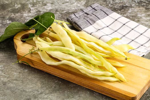 A wooden cutting board with beans on it photo