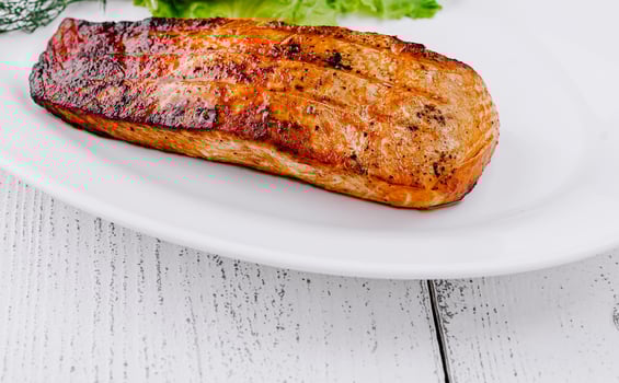 Grilled salmon fillet lying on a white plate photo