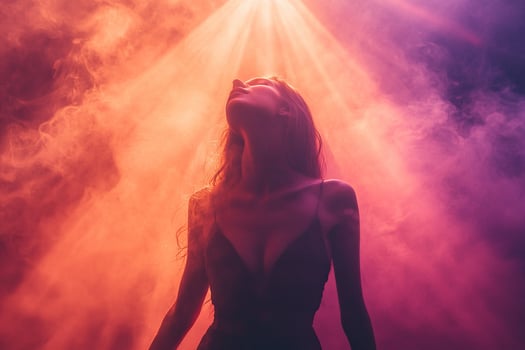 Silhouette of a gracefully dancing woman in a blue haze and bright spotlights. photo