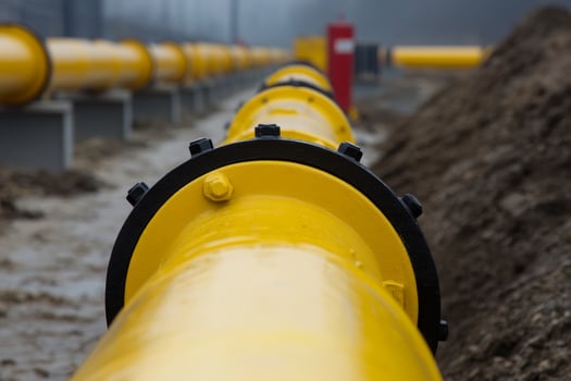 Industrial pipeline system under overcast weather conditions near a construction site with earthworks in progress photo