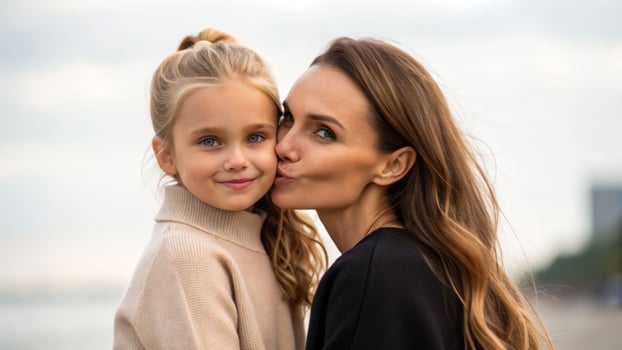 Heartwarming summertime moment between mother and daughter at the beach outdoor family bonding joyful atmosphere photo