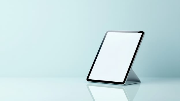 A tablet is sitting on a table with a blue background photo