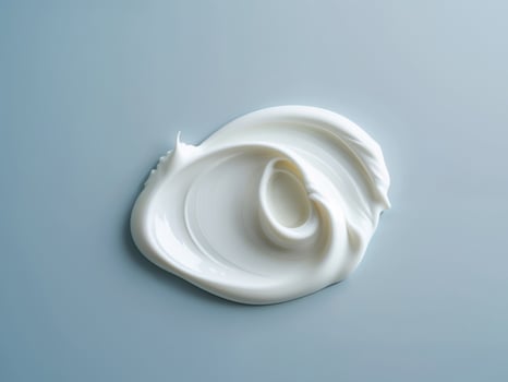 A white cream is sitting on top of a blue surface photo