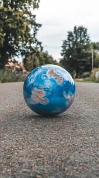 A blue globe sitting on the road photo