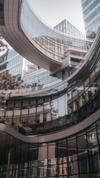 A building with a curved glass facade and a lot of windows photo