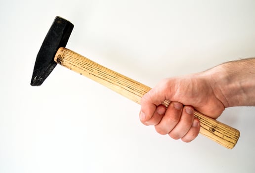 Man's hand holding hammer isolated on white background photo