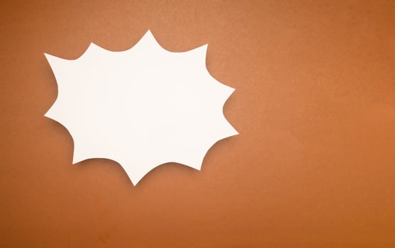 A blank white comic speech bubble on a brown background photo