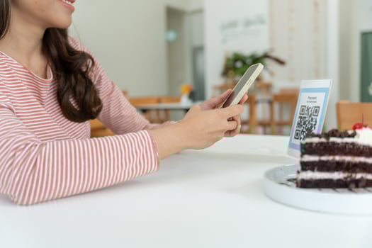 Woman use smartphone to scan QR code for order menu in cafe restaurant with a digital delivery. Choose menu and order accumulate discount. E wallet, technology, pay online, credit card, photo