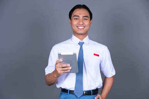 Indonesian Male High School Students in Uniform Smiling Holding Tablets Isolated Background photo