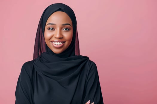 Portrait of a beautiful young muslim woman smiling on pink background photo