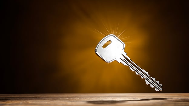 A shining silver key suspended in mid-air against a warm, glowing background, symbolizing opportunity photo