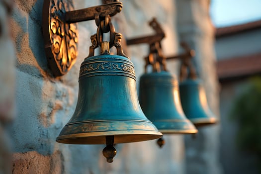 Three ancient bells hanging on a stone wall, ringing for celebration photo