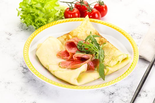 A plate with a crepe and a salad on it photo