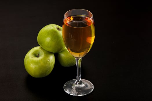 A glass of wine and a bunch of green apples photo