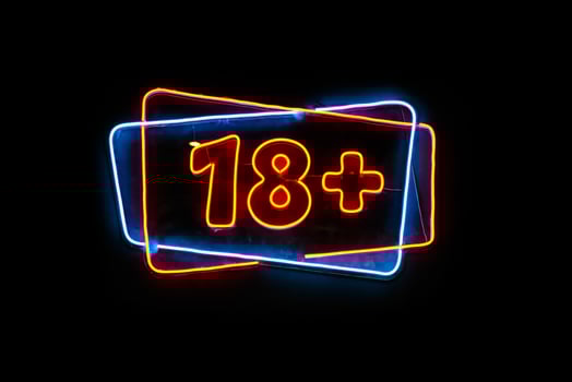 Neon light sign with 18 plus text on black background photo