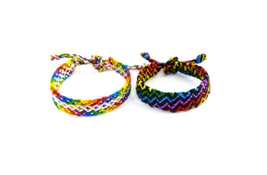 Multicolorside view of DIY friendship bracelets handmade of embroidery bright thread with knots isolated on white background photo