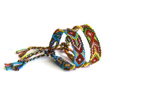indian style woven DIY friendship bracelets handmade of embroidery bright thread with knots isolated on white background photo