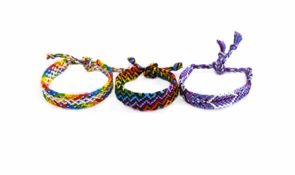 3 Multicolored woven DIY friendship bracelets handmade of embroidery bright thread with knots isolated on white background photo