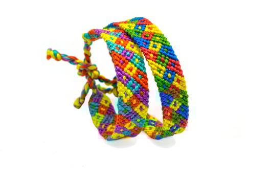 2 abstract woven DIY friendship bracelets handmade of embroidery bright thread with knots isolated on white background photo