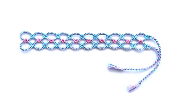 Blue woven DIY friendship bracelet handmade of embroidery bright thread with knots isolated on white background photo