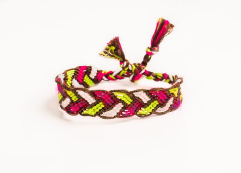 pigtail friendship bracelet handmade of embroidery bright thread with knots isolated on white background photo