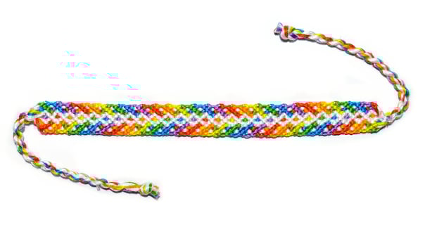 untied woven DIY friendship bracelet made of embroidery bright thread with knots isolated on white background photo