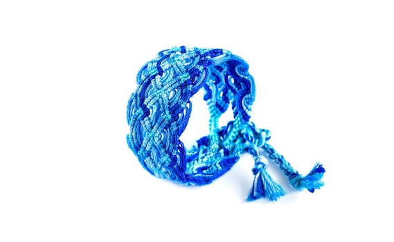 blue DIY friendship bracelets handmade of embroidery bright thread with knots isolated on white photo