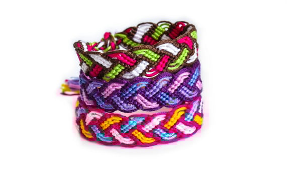 pigtails DIY friendship bracelets handmade of embroidery bright thread with knots isolated on white background photo