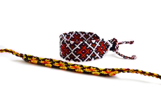 tied and untied multicolored woven DIY friendship bracelets handmade of embroidery bright thread with knots isolated on white background photo
