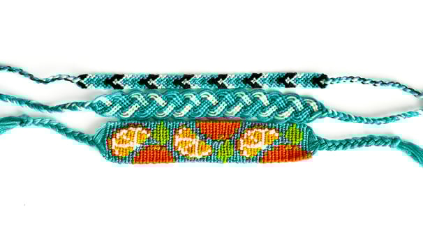 Three aqua DIY friendship bracelets handmade of embroidery floss with knots in blue colors photo