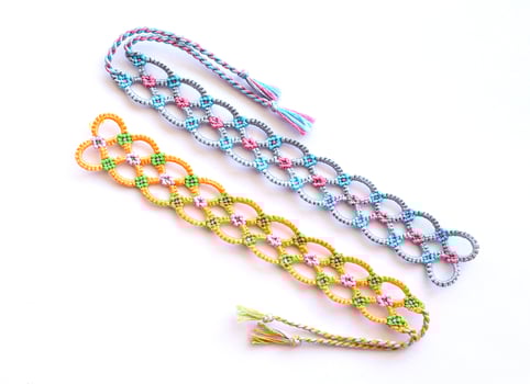 2 DIY friendship bracelets made of embroidery bright thread with knots isolated on white background photo