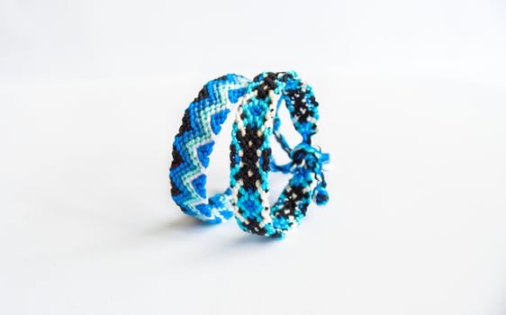 2 blue woven DIY friendship bracelets handmade of embroidery bright thread with knots isolated on white background photo