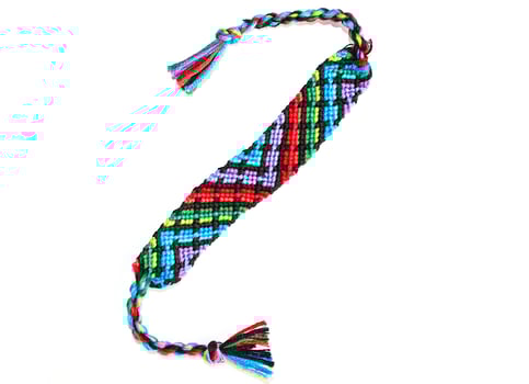 one geometrical woven DIY friendship bracelets handmade of embroidery bright thread with knots isolated on white background photo