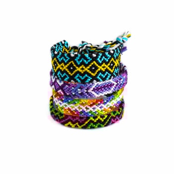 several tied woven DIY friendship bracelets handmade of embroidery bright thread with knots isolated on white background photo