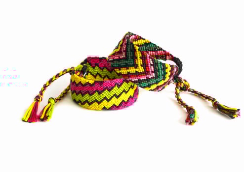 2 tied Multicolored woven friendship bracelets handmade of embroidery bright thread with knots isolated on white background photo