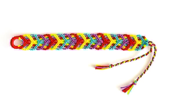 one untied woven DIY friendship bracelet handmade of embroidery bright thread with knots isolated on white background photo