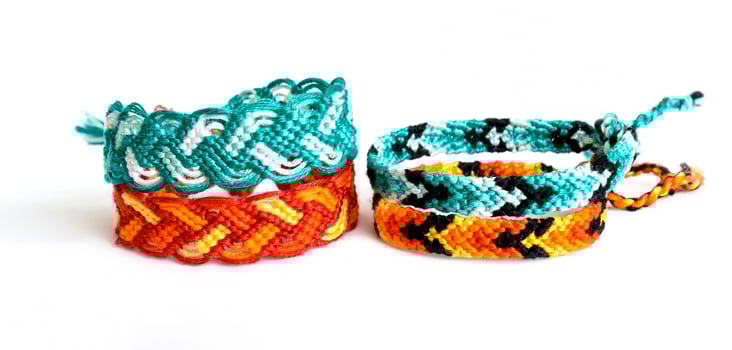 blue and orange DIY friendship bracelets handmade of embroidery bright thread with knots isolated on white background photo