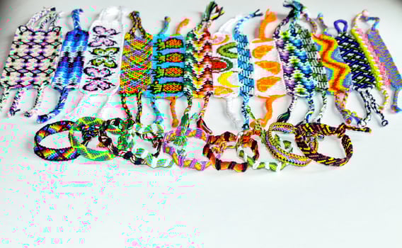tied and untied woven DIY friendship bracelets handmade of embroidery bright thread with knots isolated on white background photo