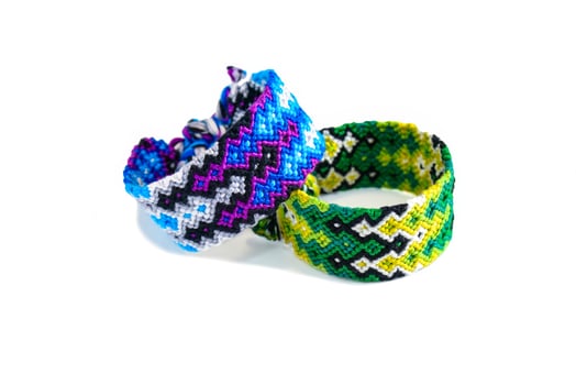 2 tied DIY friendship bracelets handmade of embroidery bright thread with knots isolated on white background photo