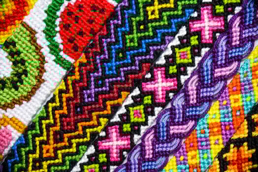 Multicolored woven DIY friendship bracelets made of embroidery thread with knots isolated on white background photo