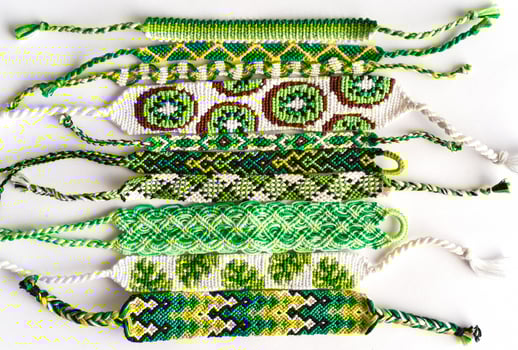 Woven DIY friendship bracelets handmade of embroidery floss with knots in green style photo