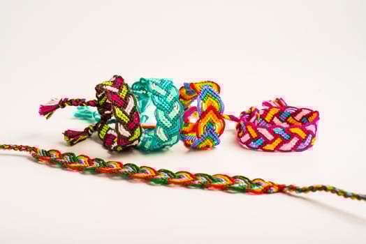 Multicolored woven pigtails friendship bracelets handmade of embroidery bright thread with knots isolated on white background photo