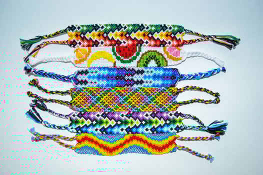 top view of woven DIY friendship bracelets handmade of embroidery bright thread with knots isolated on white background photo