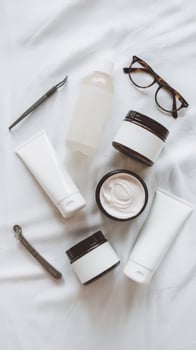 A variety of beauty products on a bed photo