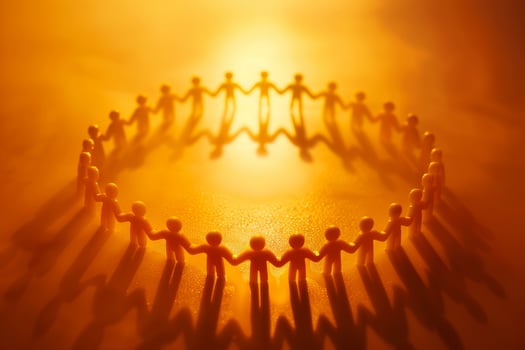Silhouettes of paper cutout figures standing in circle, holding hands photo
