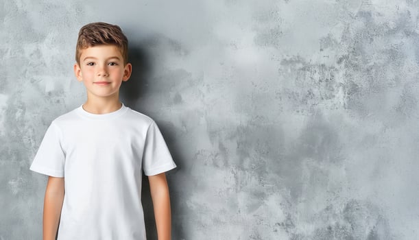 Smiling blond child boy in white t shirt mockup posing confidently during studio photoshoot neutral gray background Design template photo