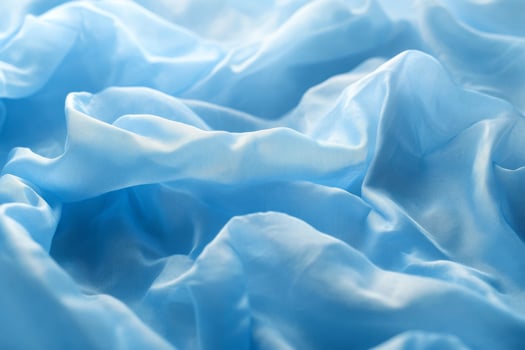 Delicate blue fabric draped elegantly, showcasing soft textures and folds. photo