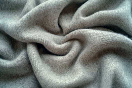 Close-up of soft, luxurious grey fabric, showcasing its smooth texture and intricate folds. photo