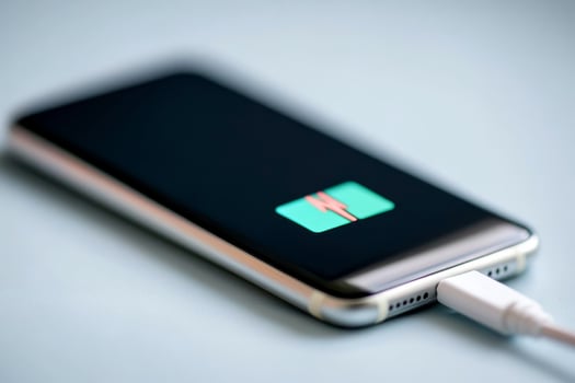 Mobile phone charging with a modern design on a blue background during daytime photo