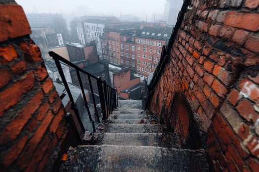 Staircase leading down from rooftop in urban area during foggy morning photo